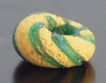 クリアな青緑に鮮やか黄で、回転する輪状モチーフを描くモザイク平玉　前後～6C頃の